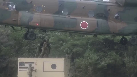 Soldiers hold chains of sling load at CH-47 Chinook hovers above Video stock 94657760