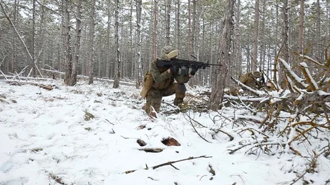 Soldiers lie down on the ground, aiming through the sight of an assault rifle Stock Footage 127618864