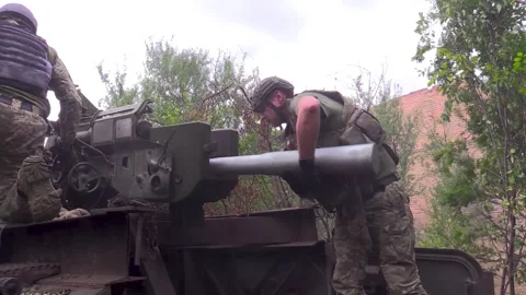 Soldiers load a cannon. Insert a large projectile into the hole Stock Footage 252758514