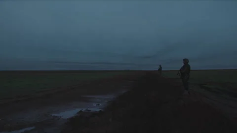 Soldiers patrolling a desolate border at dusk Stock Footage 330565586