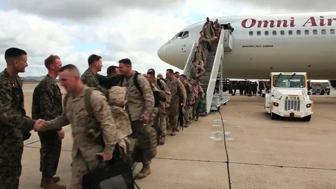 Soldiers return from deployment overseas to reunite with their families. Stock Footage 74812286