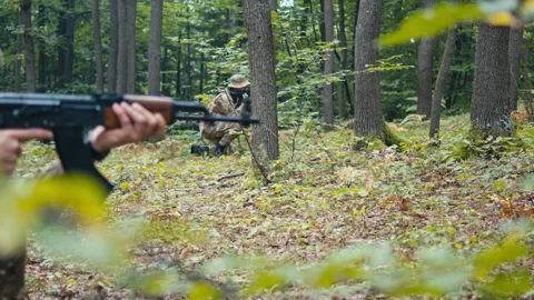 Soldiers With Rifles Crouch in the Woods | Stock Video | Pond5