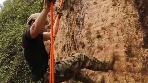 Soldiers scaling down a mountain Stock Footage 109354316