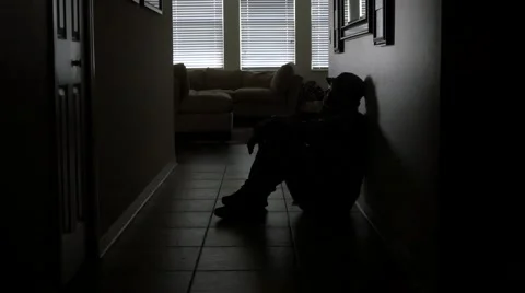 A soldier's sits in a dark hallway while dealing with PTSD, WIDE, 4K Stock Footage 53192313