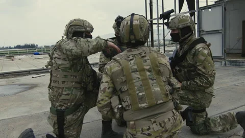 Soldiers talking and pointing while on roof Stock Footage 275094815
