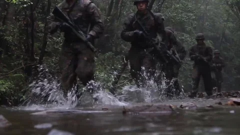 Soldiers train running in stream with assault rifles Stock Footage 109574970
