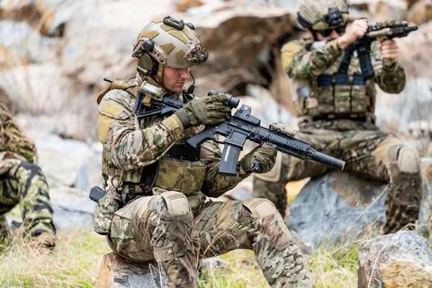 Soldiers training in a rocky area while handling weapons during military ex.. Stock-Fotos