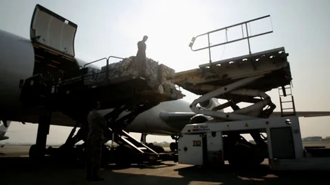 Soldiers unload cargo from a plane Stock Footage 109614357