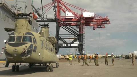Soldiers use a crane to secure a CH47 spreader bar Stock Footage 113296807