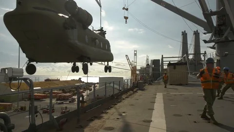 Soldiers use ropes to steer CH-47F Chinook onto deck Stock Footage 113296895