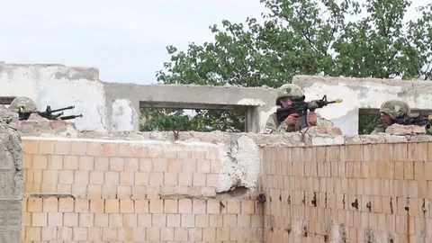 Soldiers using wall as cover fire rifles during urban operations exercise Stock Footage 93644049
