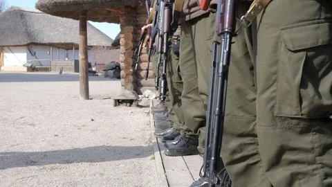 Soldiers with weapons stand in one row. View of an automatic weapon, close-up. Stock Footage 241084053