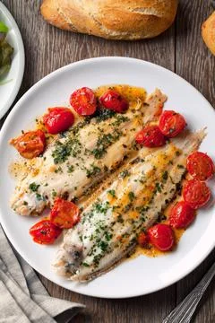 Sole with cherry tomatoes on a plate. High quality photo. Stock Photos