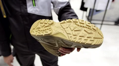 Sole of a rugged boot held in person hand. Concept of workwear and safety shoes. Stock Footage 329324116
