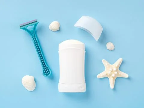 Solid antiperspirant deodorant, disposable shaving razor, sea star and shells Stock Photos