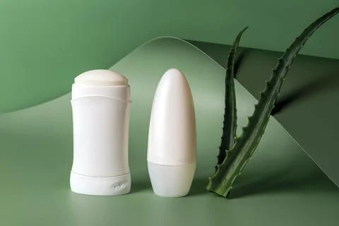 Solid antiperspirant, roll on deodorant and two fresh aloe leaves. 스톡 사진