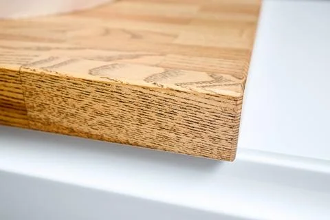 Solid ash glued timber under varnish edge corner table top selective focus macro Stock Photos