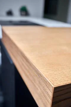 Solid ash glued timber under varnish edge corner table top selective focus ma Stock Photos