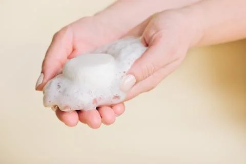 Solid bar of shampoo in woman's hands with foam. alternative type of shampoo. 스톡 사진