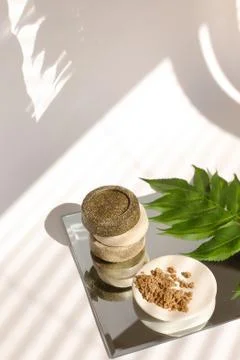 Solid bars of soap and clay powder on plate near leaf. Stock Photos