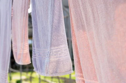 Solid bath towels hang on a rope outside Stock Photos