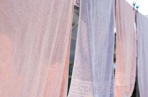 Solid bath towels hang on a rope outside Stock Photos