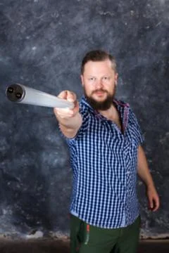 Solid bearded man at casual clothes with a fluorescent lamp looks like stick Stock Photos