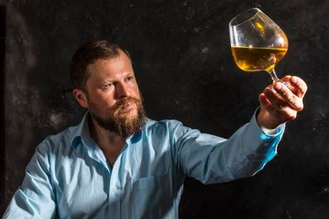 Solid bearded man in shirt with glass of whisky Stock Photos