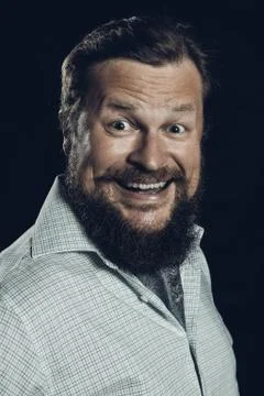 Solid bearded man in shirt smiling studio portrait on black background. Foto stock