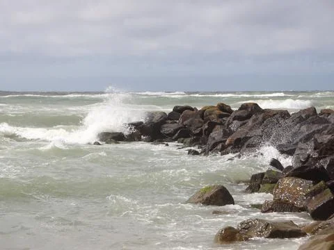 Solid breakwater rocks with cloudy sea horizon Foto stock