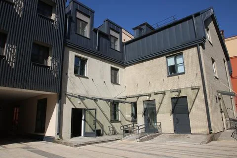 A solid brick building featuring a black roof and stairs leading up to it 스톡 사진