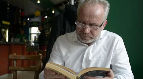 Solid business man professor reading a book in a cafe Stock Footage 61305953