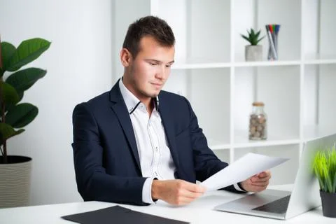 Solid businessman in a jacket works with documents in the office of the company Stock Photos