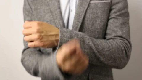 Solid caucasian man in gray jacket and speckled shirt on white background raises Stock Footage 114189426