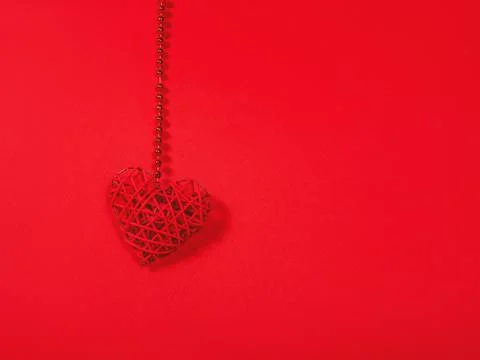 Solid colour St. Valentine's concept as a hanging red heart with copy space. Stock Photos