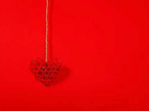 Solid colour St. Valentine's concept as a hanging red heart with copy space. Stock Photos
