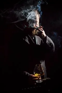 Solid confident bearded man in suit with glass of whisky and cigar Stock Photos