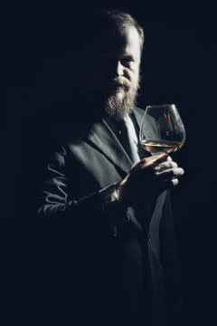 Solid confident bearded man in suit with glass of whisky Stock Photos