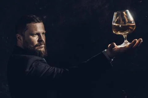 Solid confident bearded man in suit with glass of whisky Stock Photos