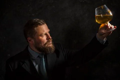 Solid confident bearded man in suit with glass of whisky Stock Photos