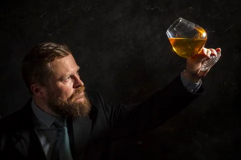 Solid confident bearded man in suit with glass of whisky Foto stock