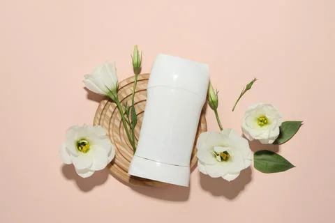 Solid deodorant and beautiful eustoma flowers on beige background, flat lay 스톡 사진