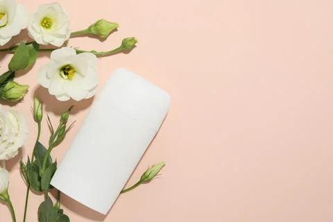 Solid deodorant and beautiful eustoma flowers on beige background, flat lay.. Stockfoto's