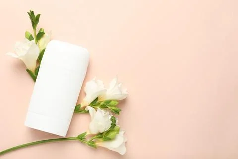 Solid deodorant and beautiful eustoma flowers on beige background, flat lay.. 스톡 사진