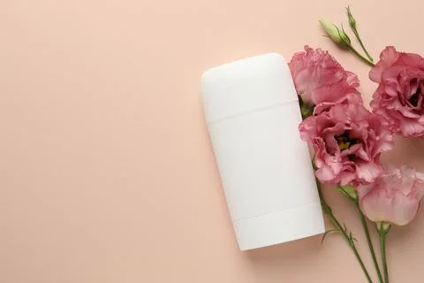 Solid deodorant and beautiful eustoma flowers on beige background, flat lay.. 스톡 사진