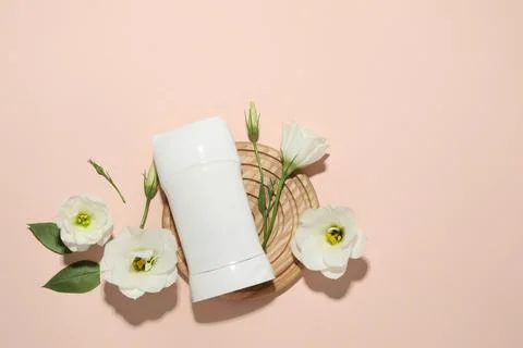 Solid deodorant and beautiful eustoma flowers on beige background, flat lay.. 스톡 사진