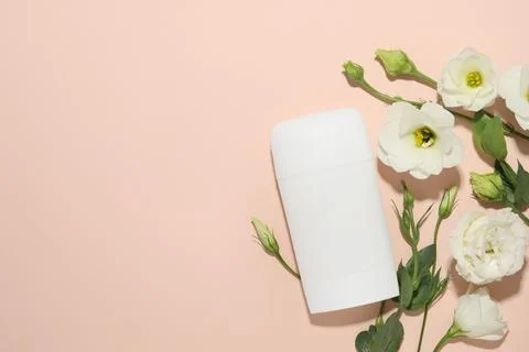Solid deodorant and beautiful eustoma flowers on beige background, flat lay.. 스톡 사진