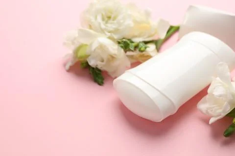 Solid deodorant and beautiful eustoma flowers on pink background, closeup 스톡 사진