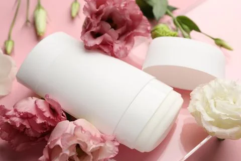 Solid deodorant and beautiful eustoma flowers on pink background, closeup 스톡 사진