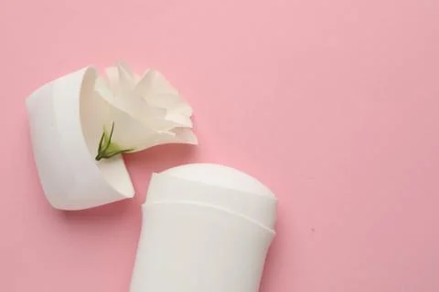 Solid deodorant and beautiful eustoma flower on pink background, top view. .. 스톡 사진